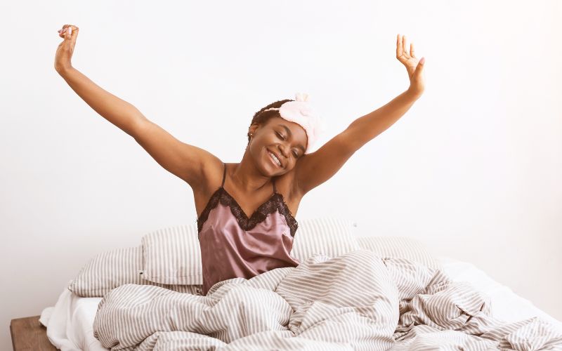 The Importance of Sleep for Menopause Weight Loss 7 Smiling woman waking up refreshed after a good night's sleep, symbolizing the positive impact of quality rest on menopause weight loss